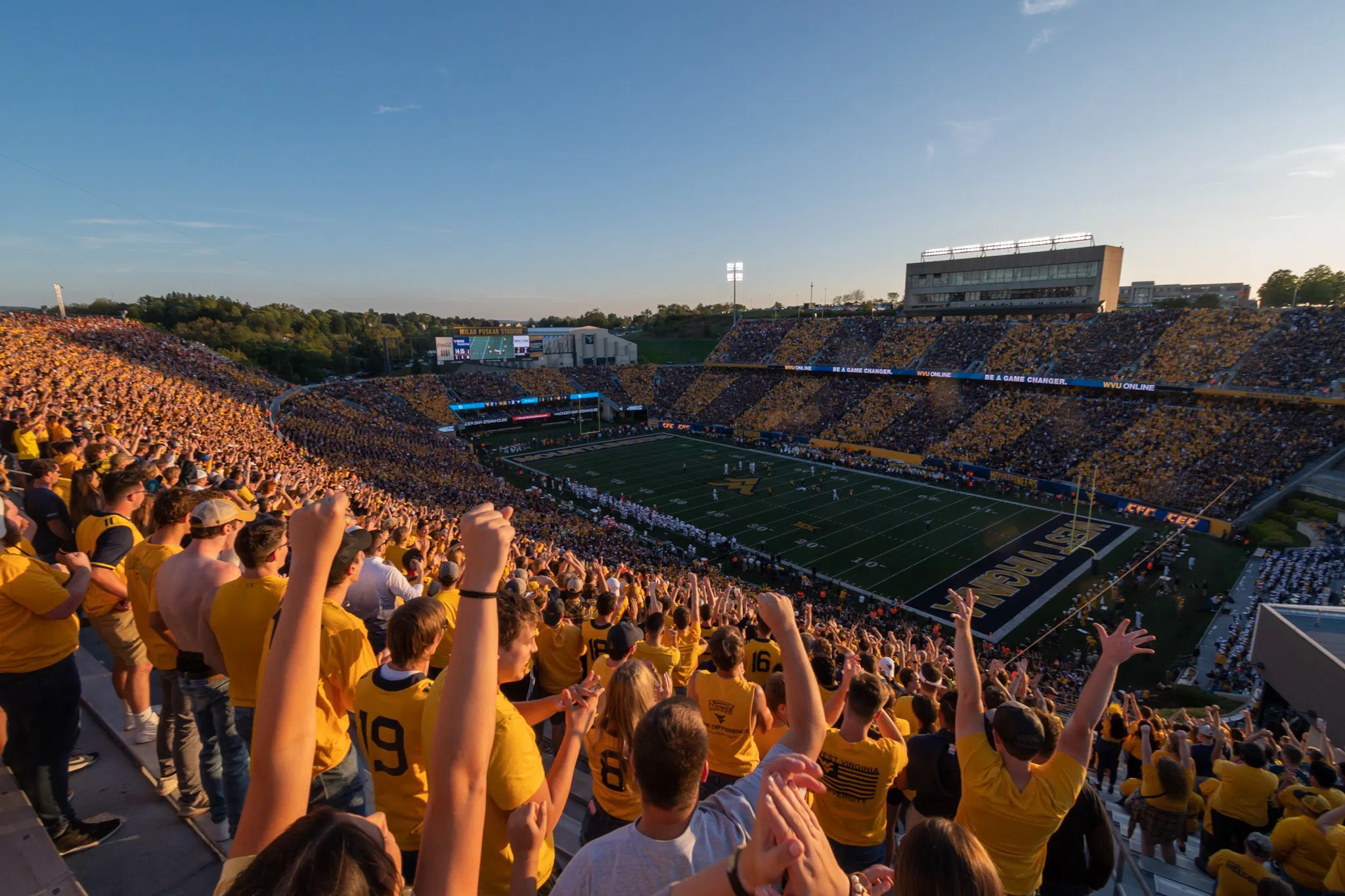 Students cheer as this photo captures the football field in the distance.  