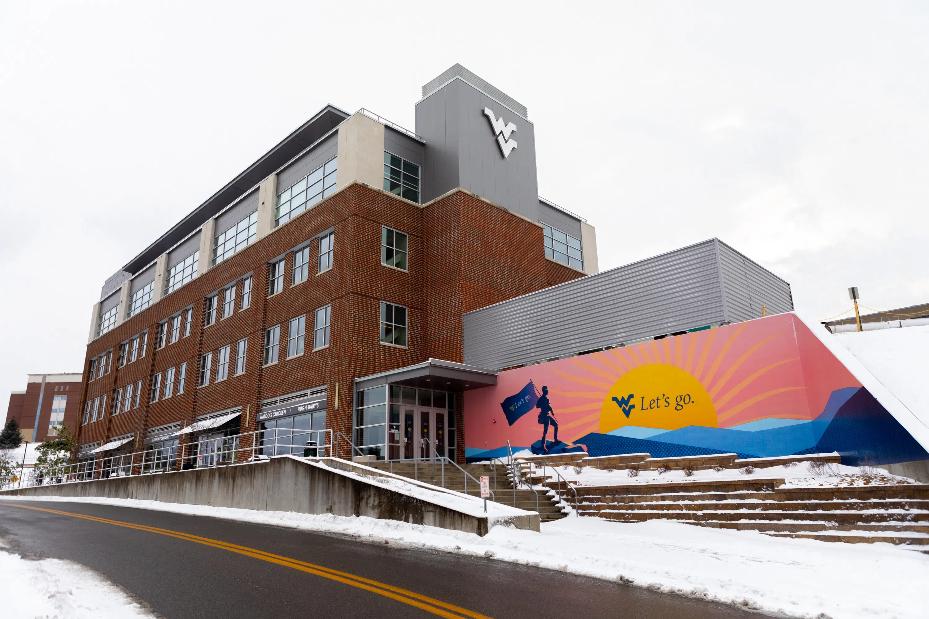 A snowy photo of the Exterior of the Evansdale Crossing 