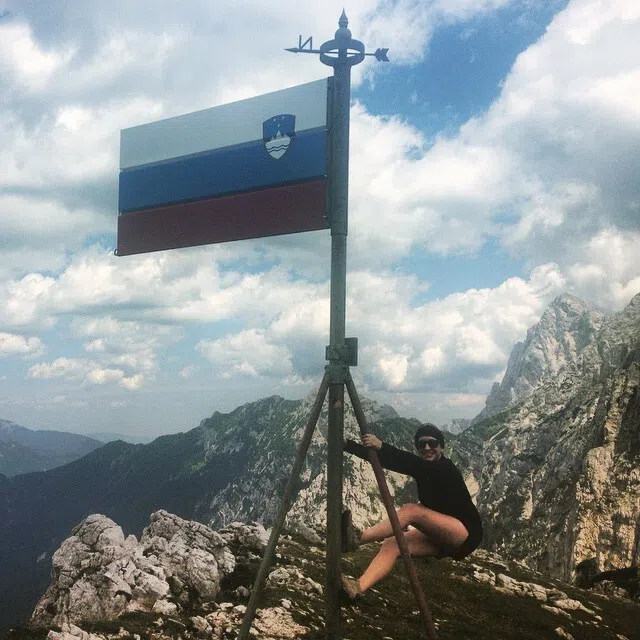 Student climbing on rocks to reach flag