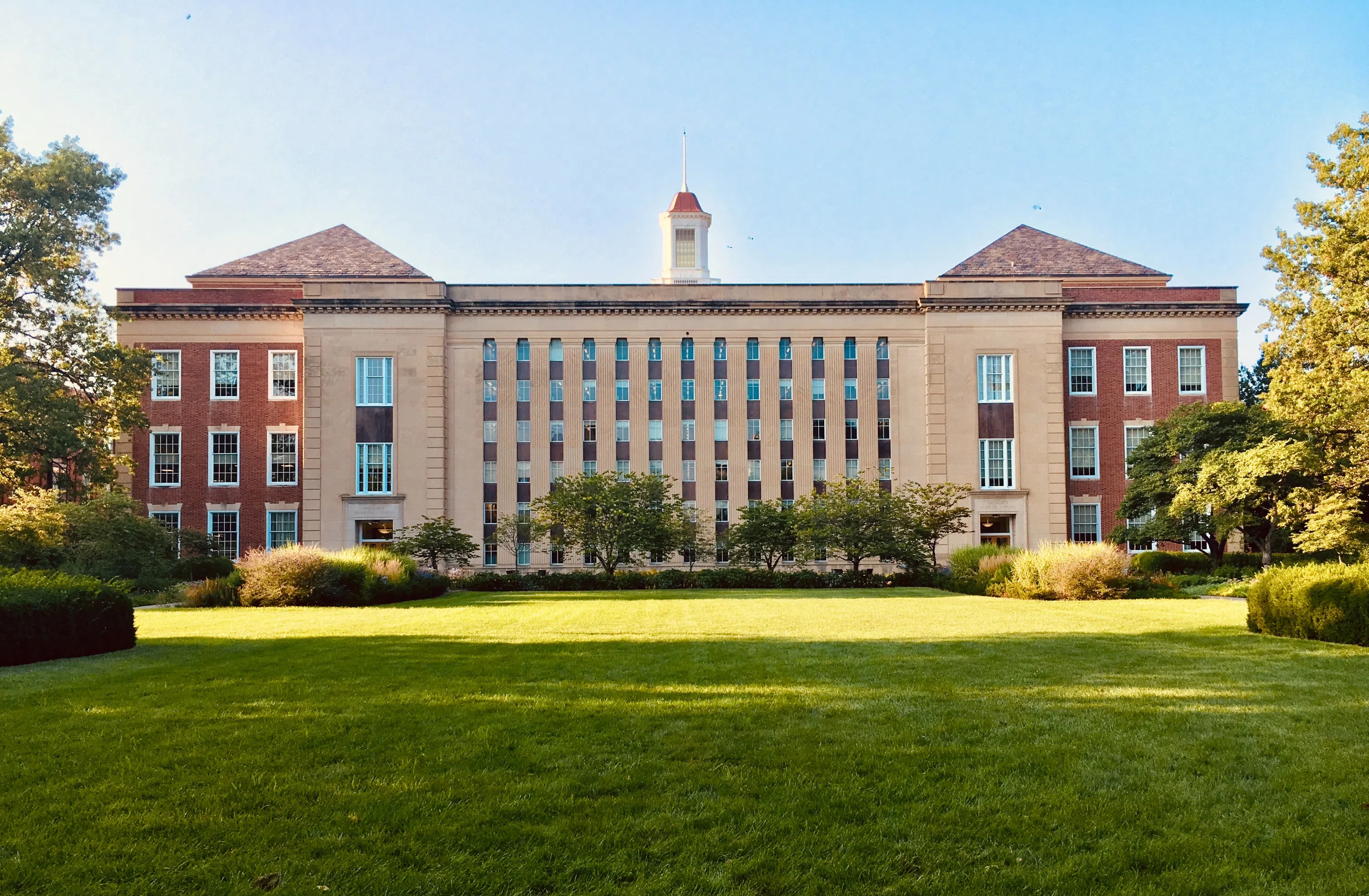 The quad with main campus building shining sunlight