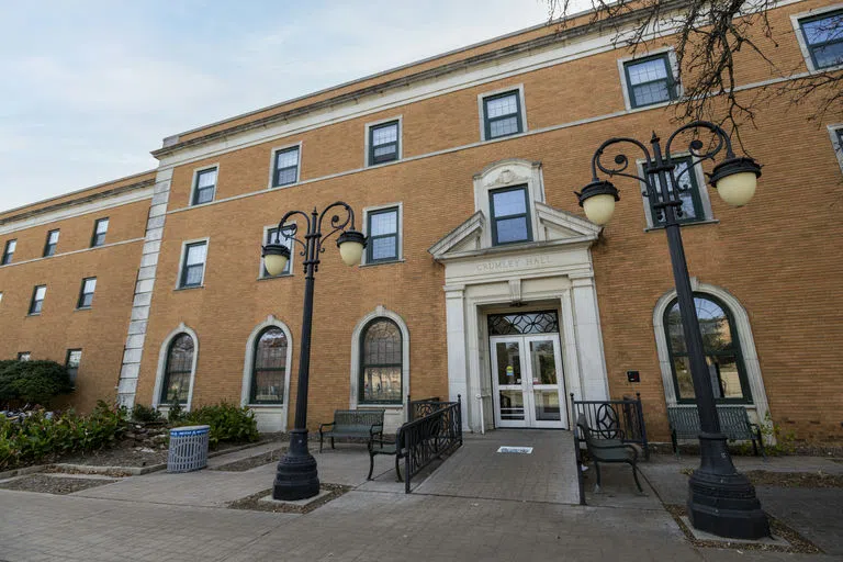  A picture of the front door of Crumley Hall, framed by two lamp posts. 