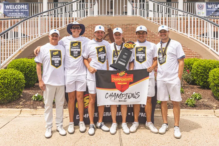 The mens golf team poses with the conference championship trophy.