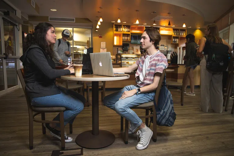 UWF students studying and socializing at the Pace Library Coffeehouse in the John C. Pace Library.