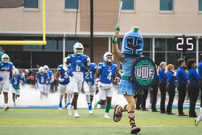 Argie, the Argonaut mascot, leads the football team onto the field. 