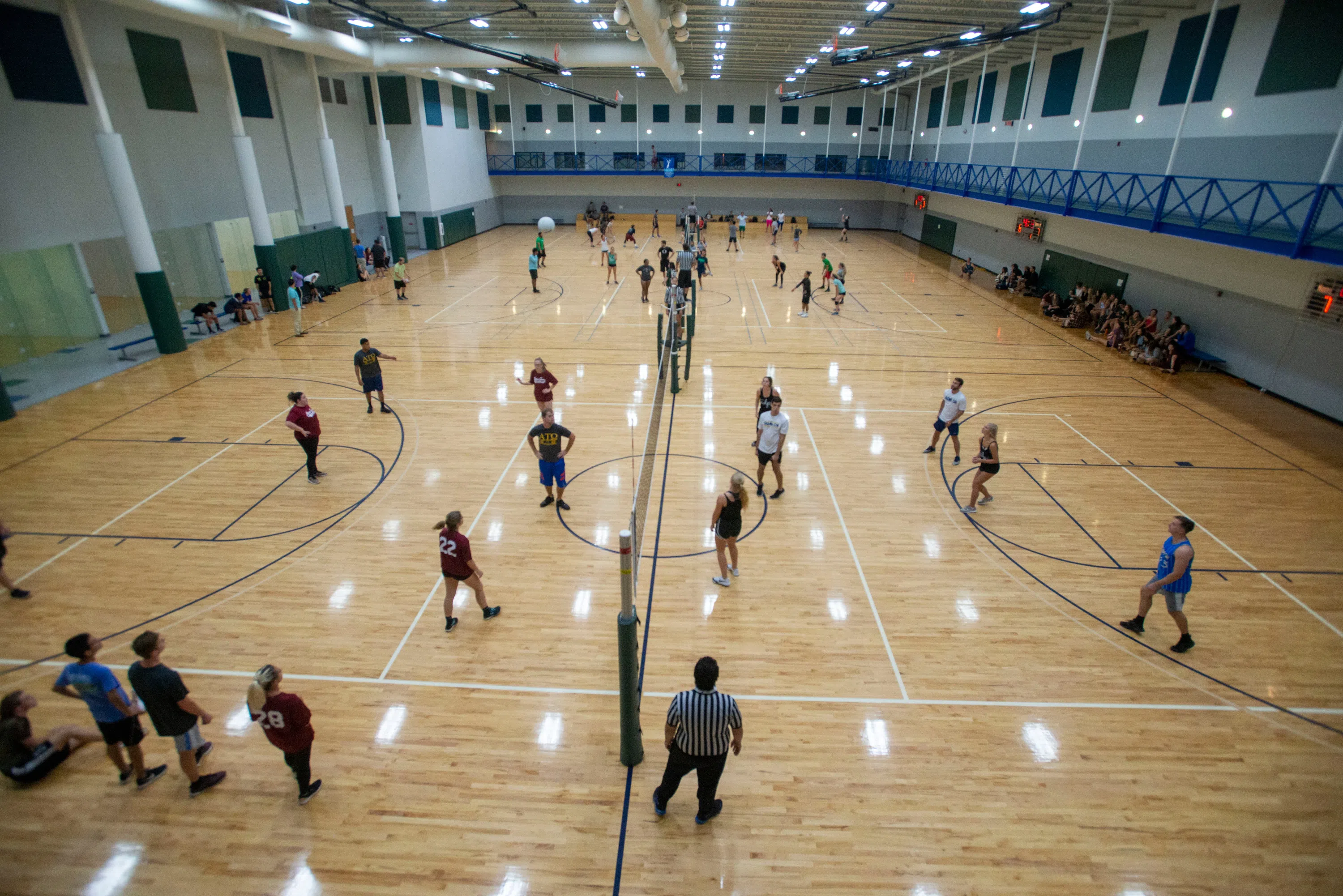 Students playing volleyball on the courts in the HLS.