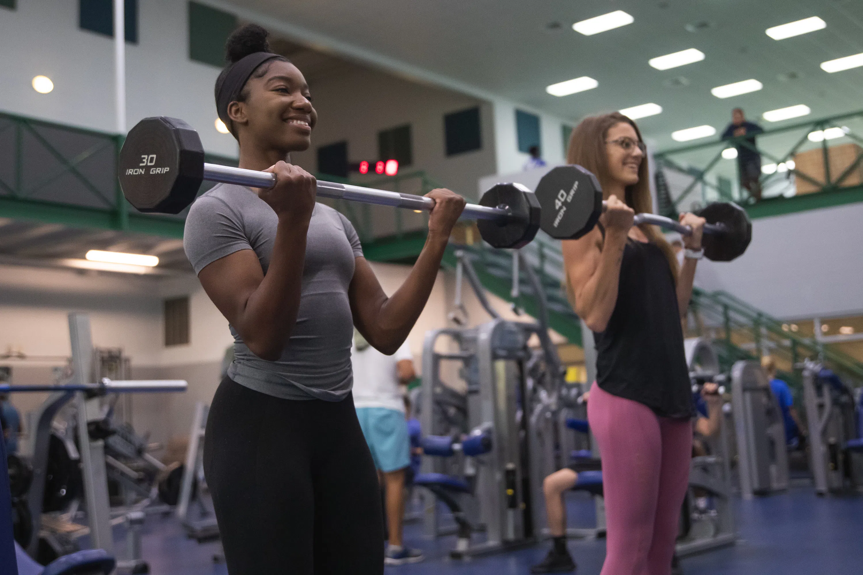 Two students lifting weights