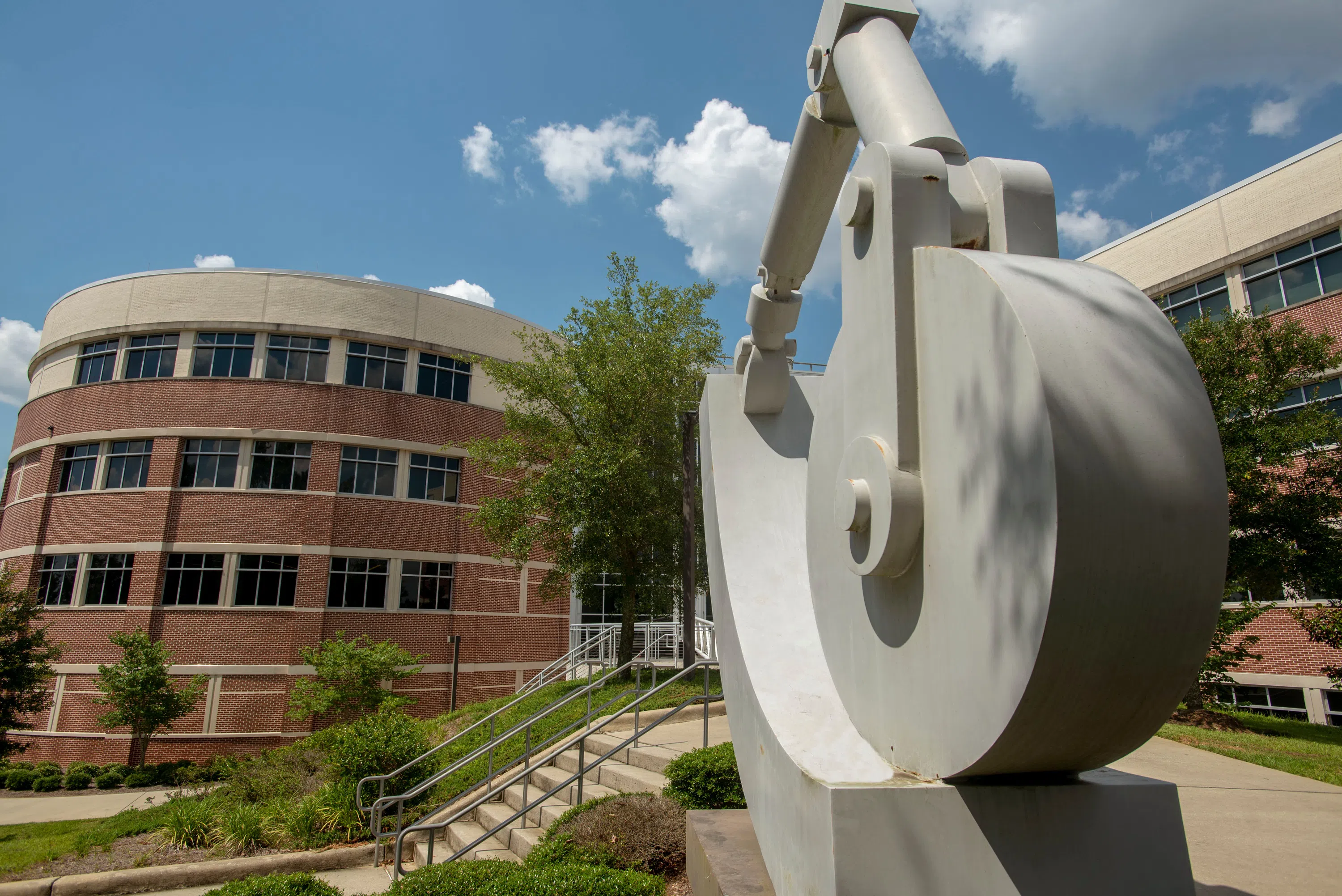 Exterior of Hal Marcus College of Science and Engineering with sculpted art piece in front.