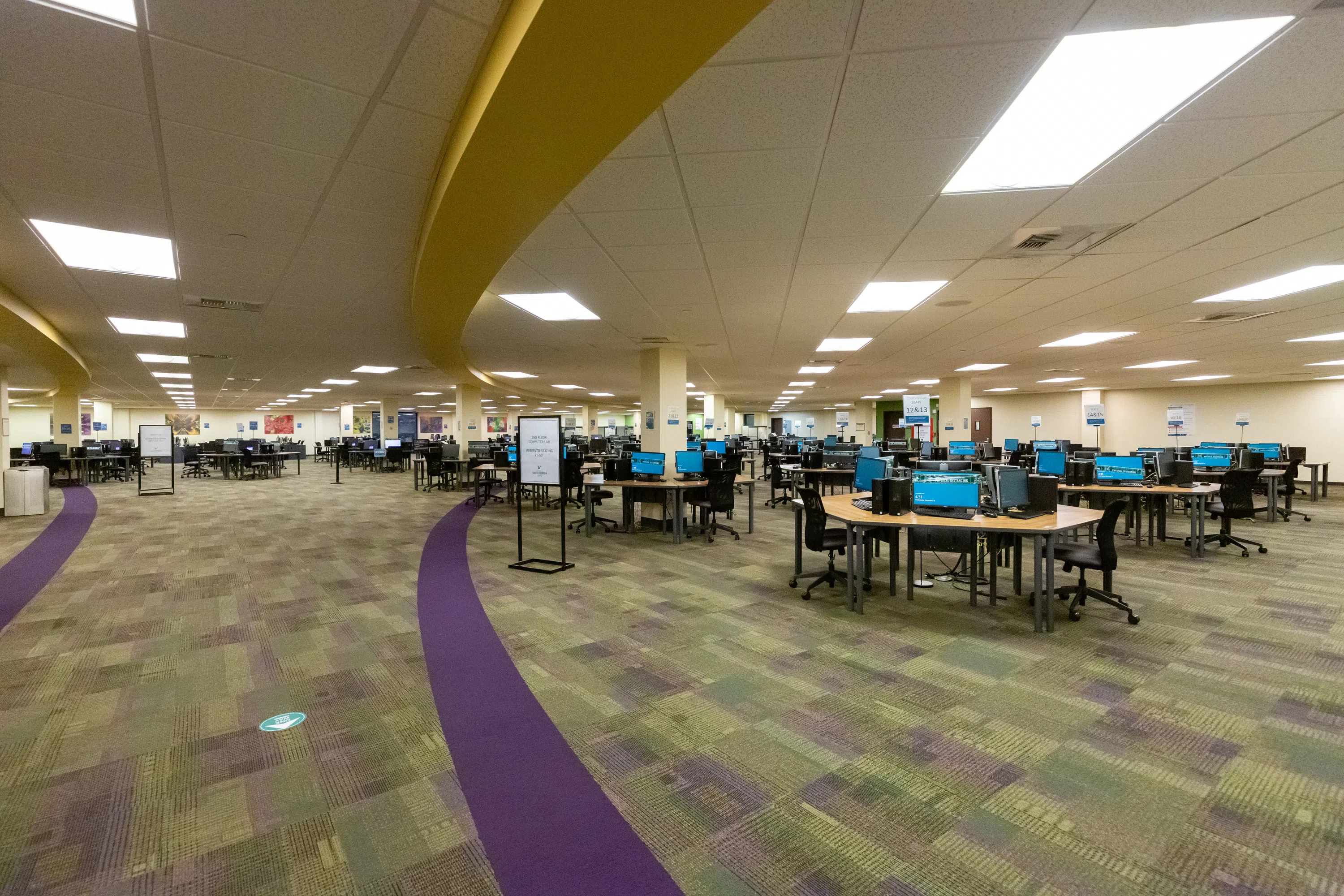 A large arrangement of computer desktop tables shaped as hexagons.