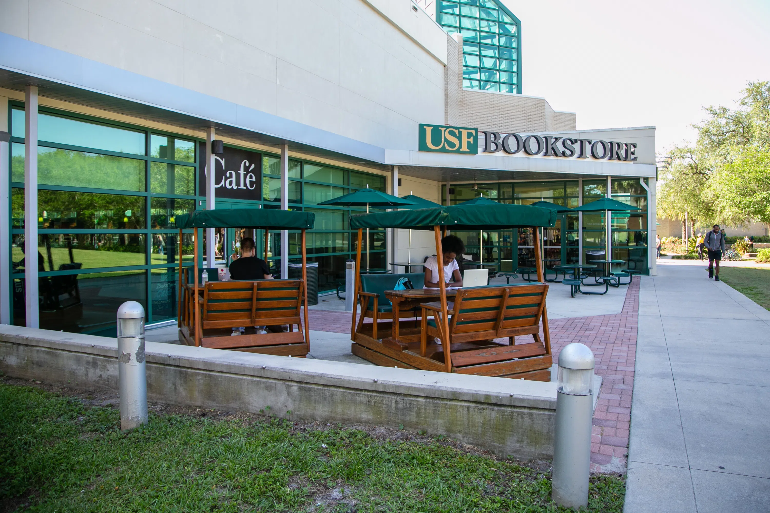 USF Bookstore Street View. Two picnic glider chairs sit next to the door way. Above reads a sign that reads "USF Bookstore".