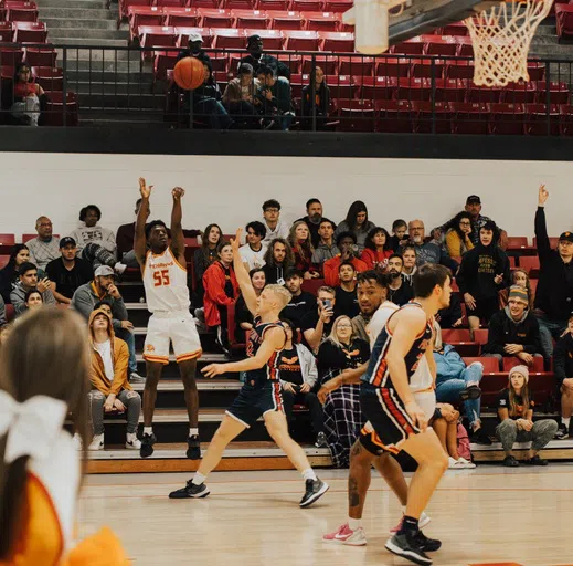 UT Southern Men's basketball team play a game in the gym with spectators in the stands. 