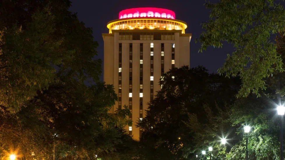 Capstone Hall at night, showing the garnet lights at the top of the building