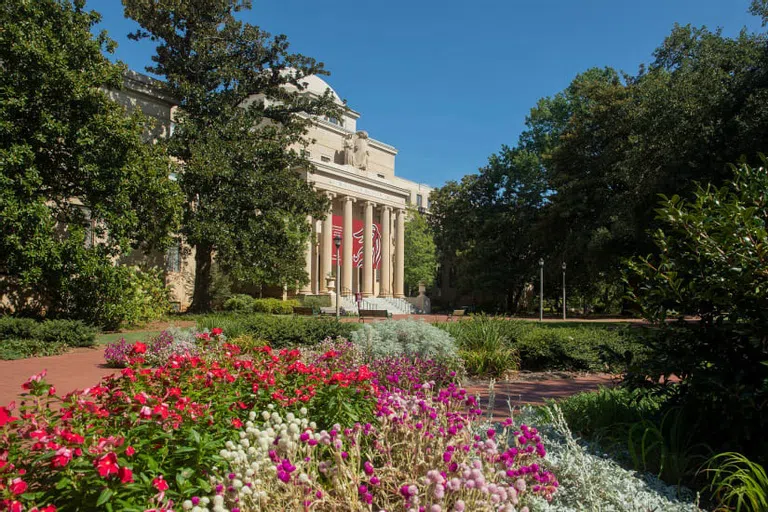 McKissick Museum with red and purple flowers in the foreground