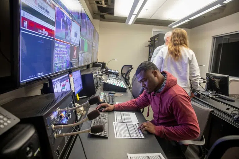 A student runs the audio board for a Carolina production.