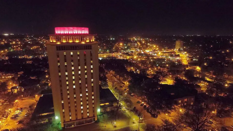 Capstone Hall at night with the lights of Columbia in the background