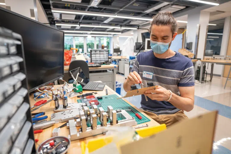 student works on an engineering project in a campus laboratory