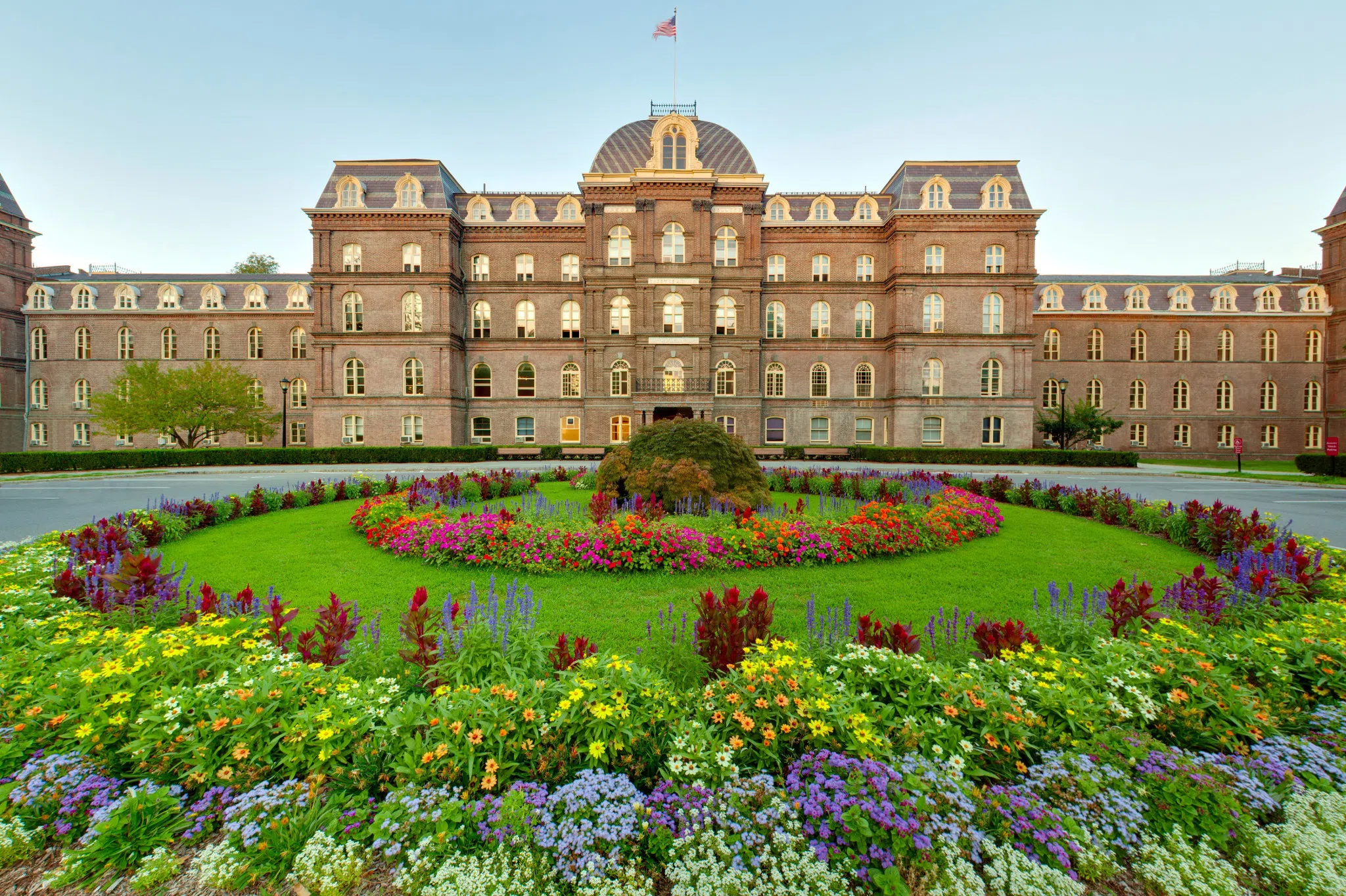 large building with many windows surrounded by flower