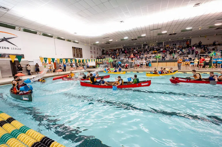 Students playing canoe battleship in Recreation Center swimming pool.