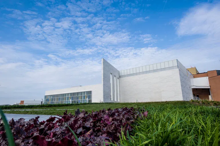 The Creative Arts Center building is shown from the outside against a blue sky.