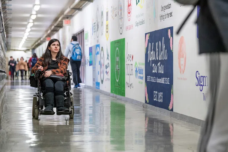 A student in a wheelchair uses the underground tunnels to navigate between buildings on campus