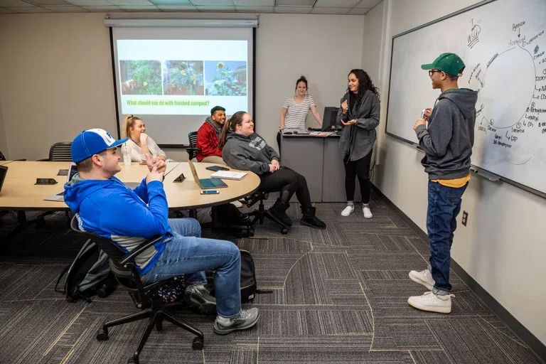 Students working on a project in a group work study room in the library.