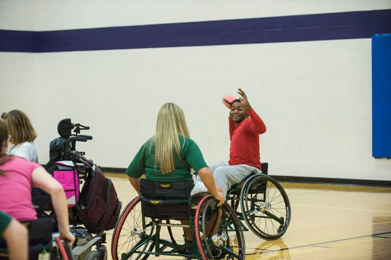 Students play wheelchair football in the gym.