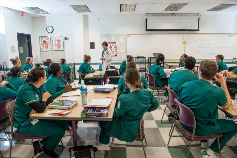 Nursing students listen to a lecture in a nursing classroom.