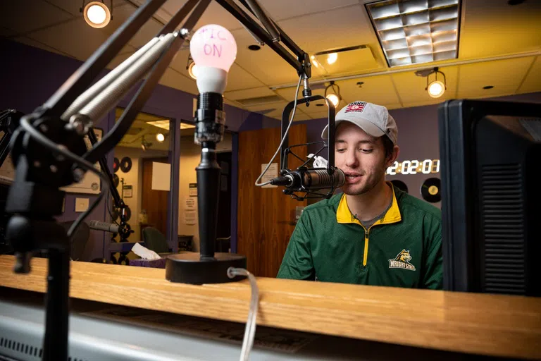 Student worker hosting a radio show on the WWSU radio station.