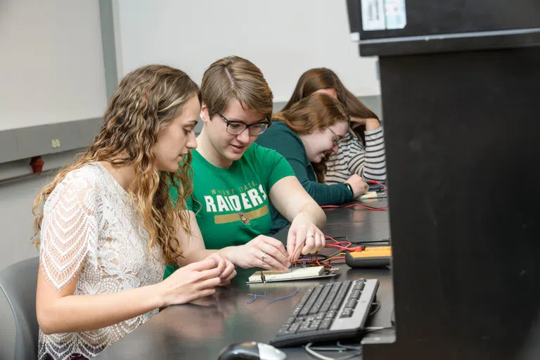 Engineering students work on circuits. 