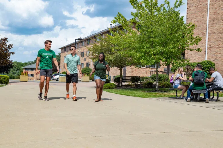 Students hanging out outside the campus housing buildings.