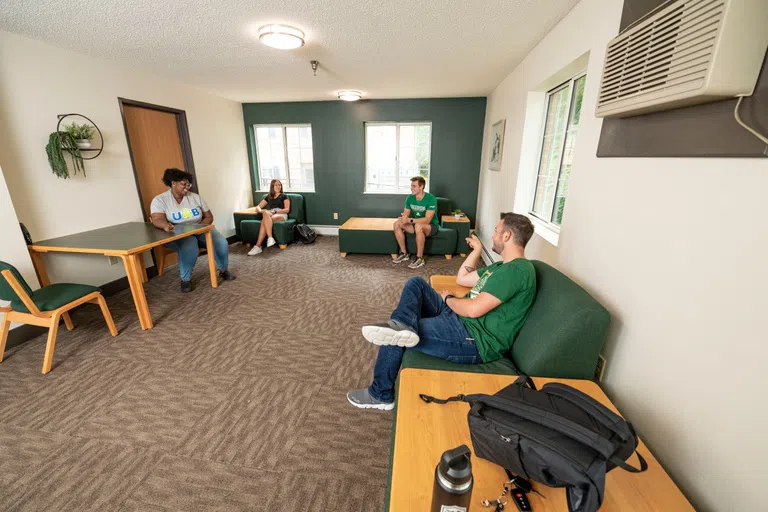 Students hanging out in a common area inside a campus housing building.