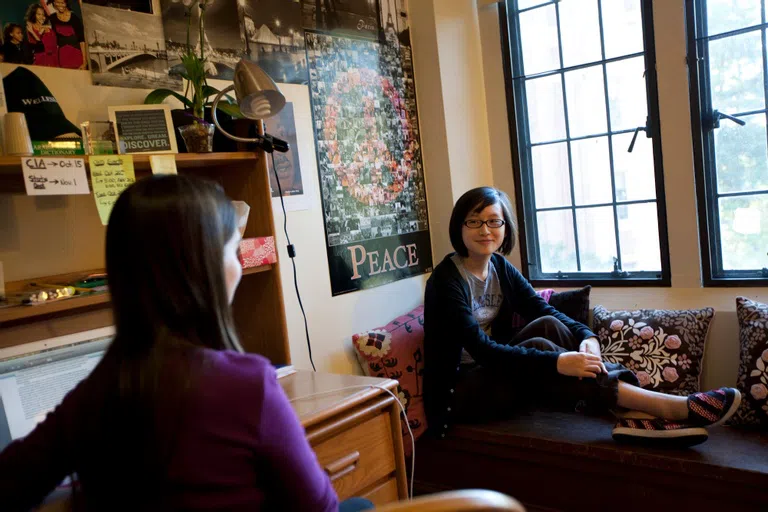 Wellesley students chatting by a window in a residence hall