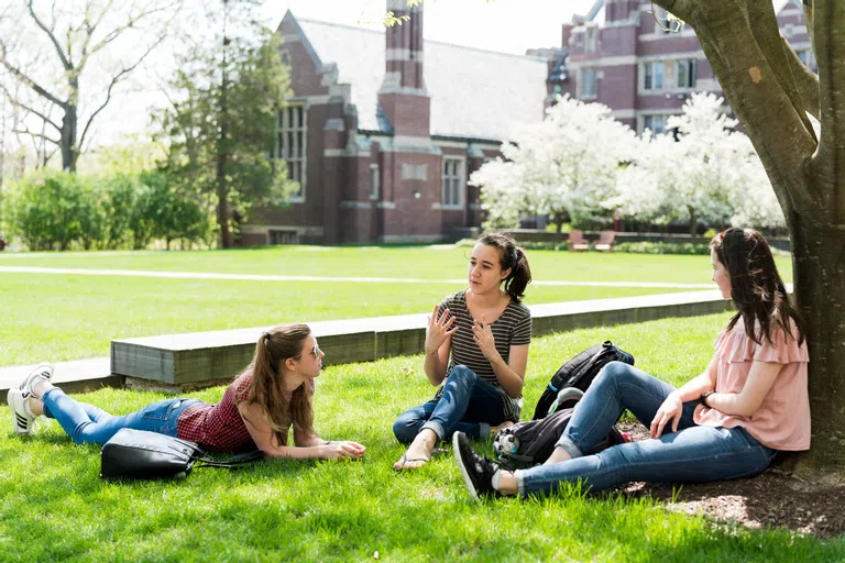 Wellesley students sitting out on the lawn