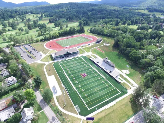 aerial of the athletic complex with two fields and a track, surrounded by trees and buildings