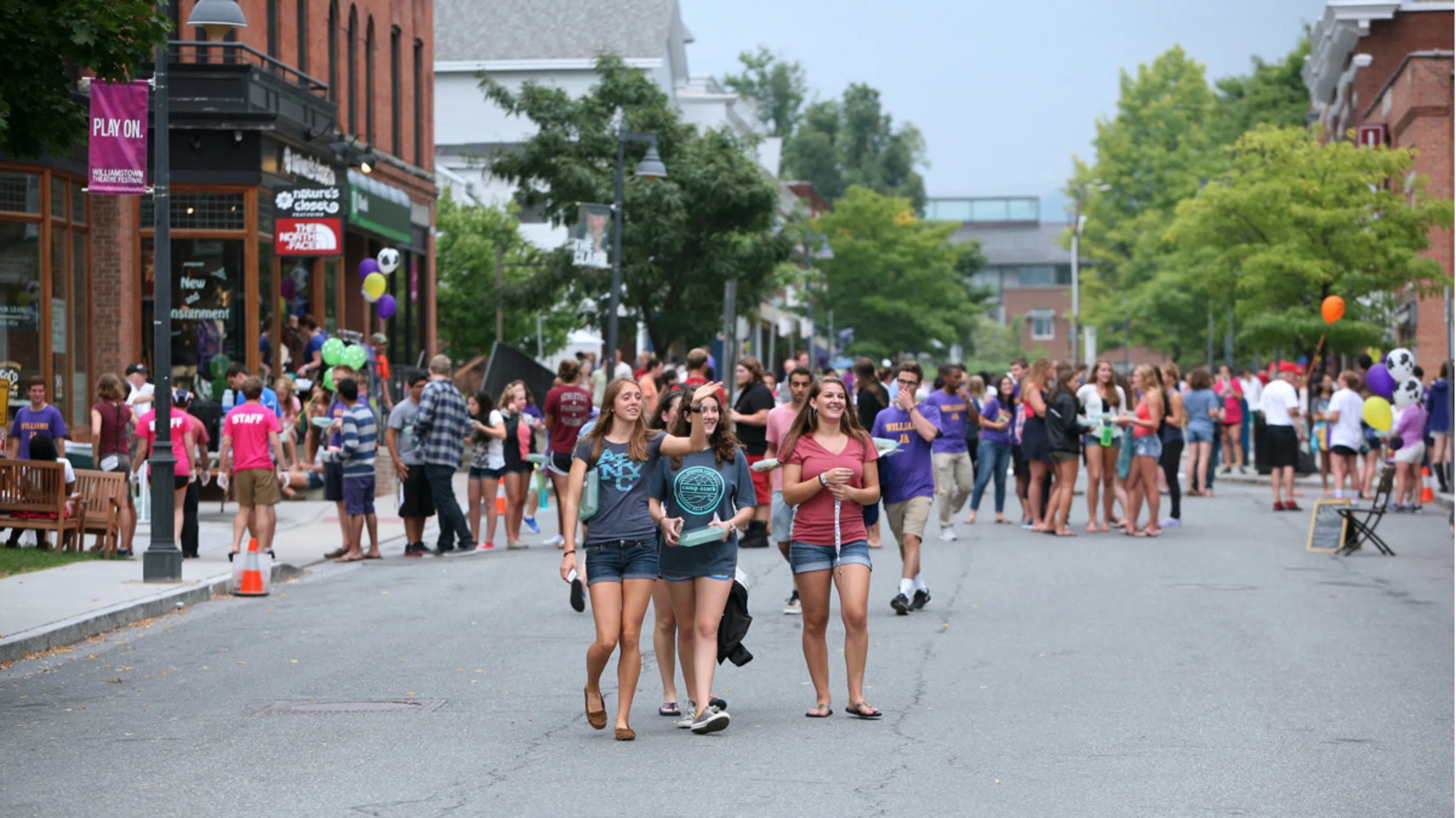 A large crowd of smiling and laughing students walking down Spring Street