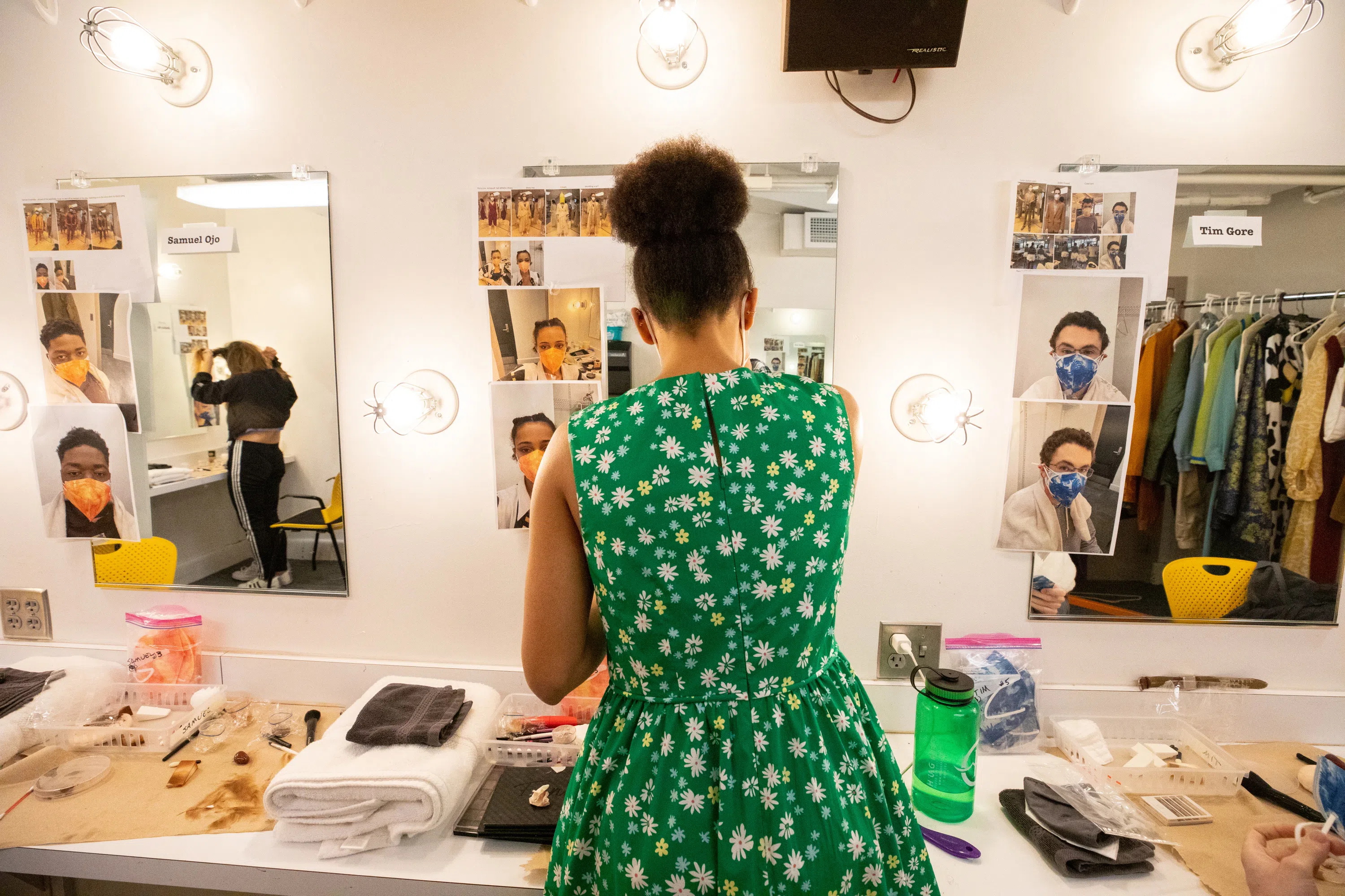 a student getting prepared for a show in front of a dressing room mirror