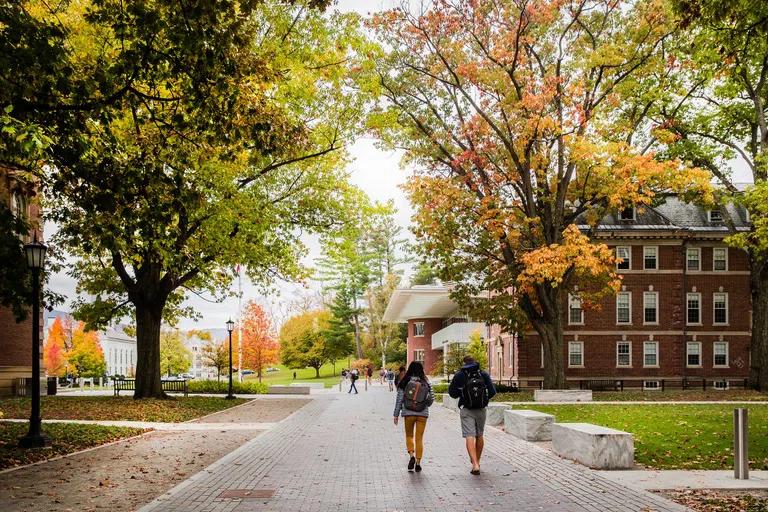 Students walking on the stone path by Frosh Quad surrounded by fall trees