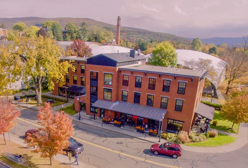 three story red brick building with sign "Tunnel City Coffee" on bottom of Spring St