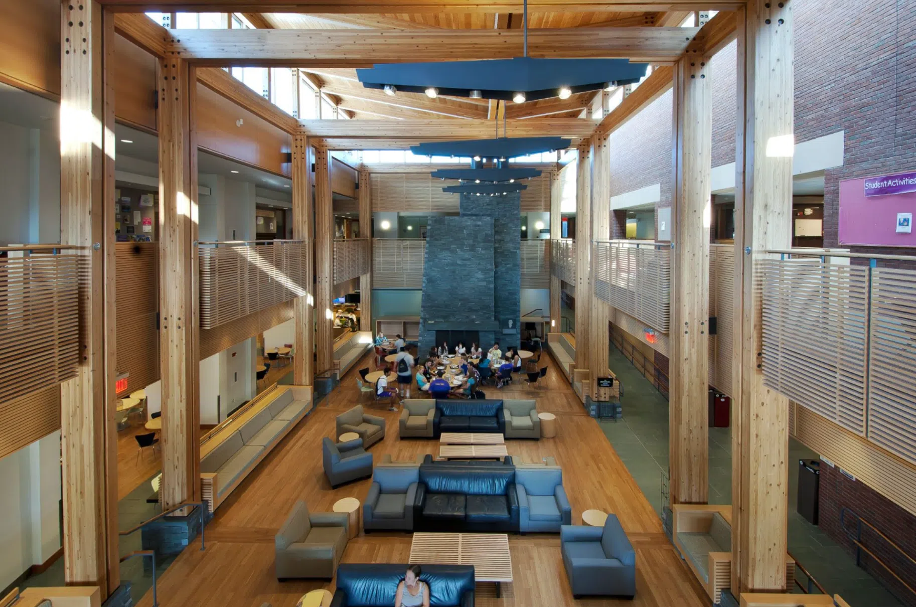 upstairs view of living room space with stone fireplace