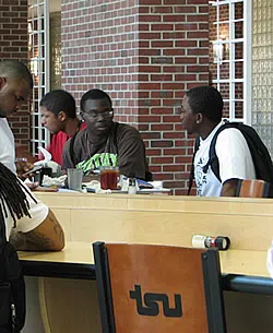 Students chatting and eating in the campus center dining hall. 