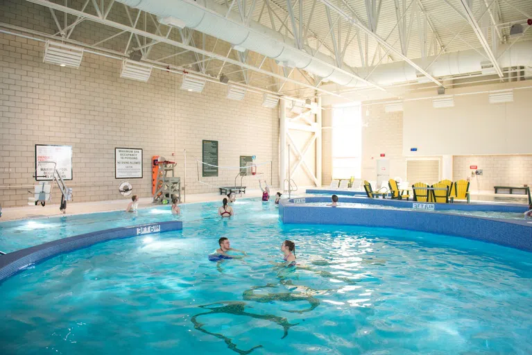 Combining fitness and fun, the leisure pool within the Aquatic Center has a vortex circle, hot tub, lounge spaces, basketball and volleyball nets, and a fire pit. 